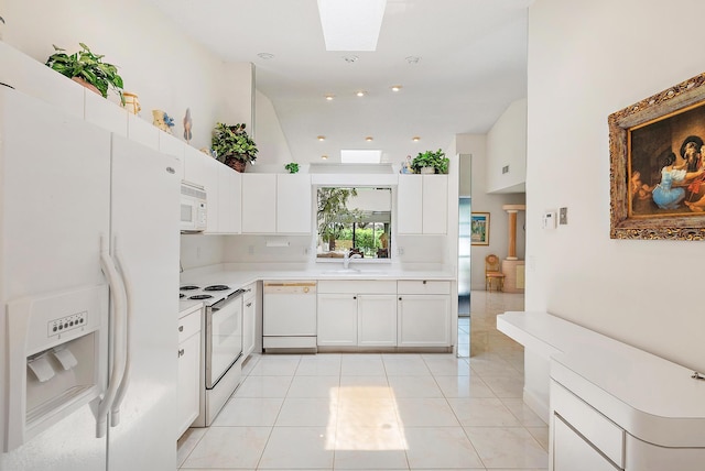8368 Sunmeadow Ln, Boca Raton, FL 33496 - kitchen with white appliances, light countertops, white cabinetry, light tile patterned floors, and a skylight