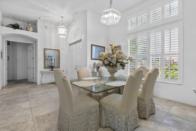1267 SW Briarwood Dr, Saint Lucie West, FL 34986 - dining area featuring a chandelier, a towering ceiling, healthy amount of natural light, and light tile patterned floors