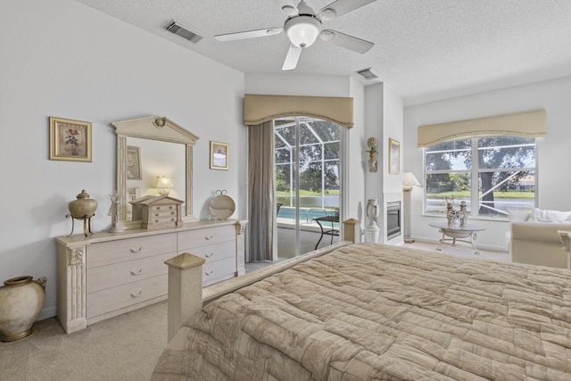 1267 SW Briarwood Dr, Saint Lucie West, FL 34986 - bedroom with access to outside, multiple windows, a textured ceiling, light carpet, and ceiling fan