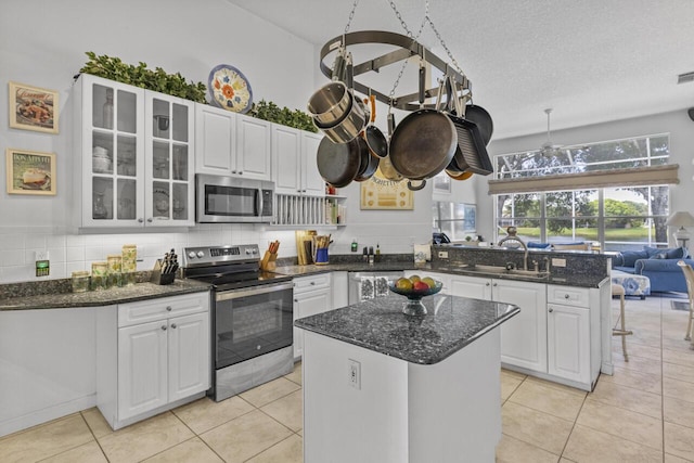 1267 SW Briarwood Dr, Saint Lucie West, FL 34986 - kitchen with appliances with stainless steel finishes, a peninsula, white cabinets, and glass insert cabinets