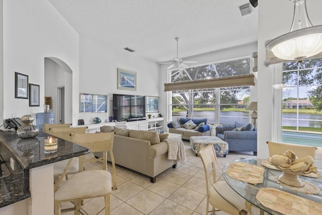 1267 SW Briarwood Dr, Saint Lucie West, FL 34986 - living area featuring a high ceiling, light tile patterned floors, arched walkways, ceiling fan, and a textured ceiling