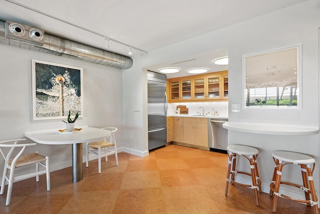 2 Church Ln Unit 115, North Palm Beach, FL 33408 - kitchen with appliances with stainless steel finishes, light flooring, glass insert cabinets, light countertops, and track lighting