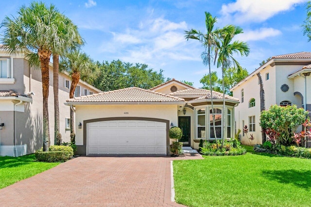 4086 Woodhill Pl, Boynton Beach, FL 33436 - mediterranean / spanish-style home with an attached garage, decorative driveway, a tiled roof, a front yard, and stucco siding