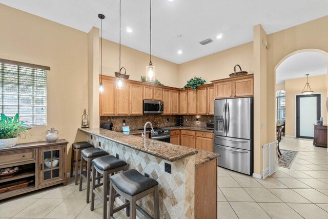 4086 Woodhill Pl, Boynton Beach, FL 33436 - kitchen featuring stainless steel appliances, a peninsula, light tile patterned floors, backsplash, and a high ceiling