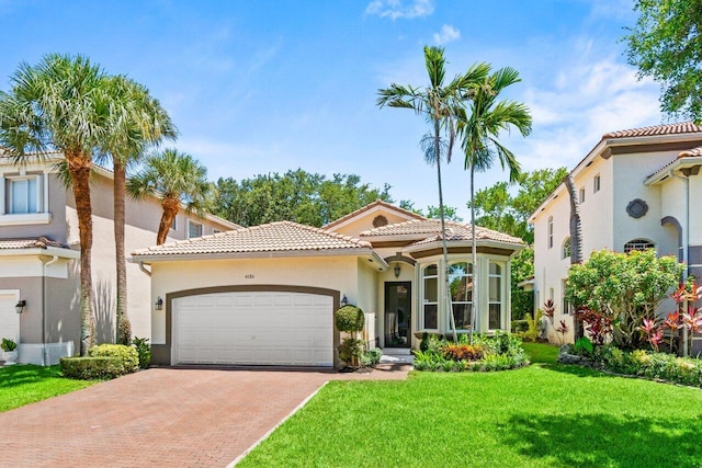 4086 Woodhill Pl, Boynton Beach, FL 33436 - mediterranean / spanish house with a tiled roof, a garage, decorative driveway, a front lawn, and stucco siding