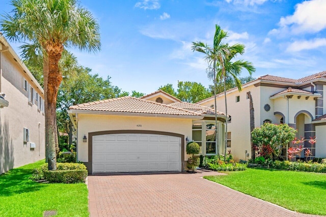 4086 Woodhill Pl, Boynton Beach, FL 33436 - mediterranean / spanish house with a tile roof, a garage, decorative driveway, stucco siding, and a front lawn