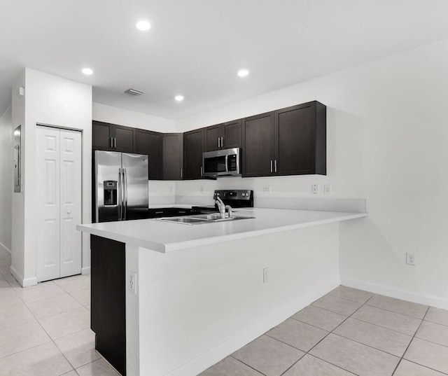 10606 W 33rd Ct, Hialeah, FL 33018 - kitchen featuring appliances with stainless steel finishes, light tile patterned floors, light countertops, a peninsula, and recessed lighting