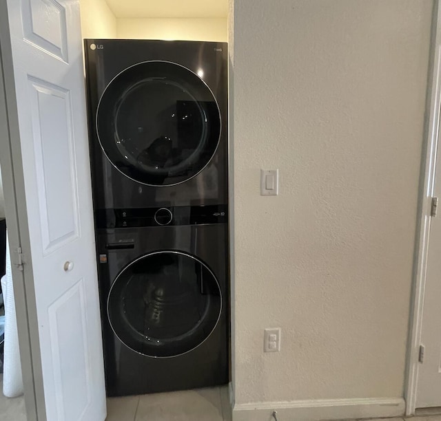 10606 W 33rd Ct, Hialeah, FL 33018 - washroom with stacked washing machine and dryer, tile patterned flooring, and a textured wall