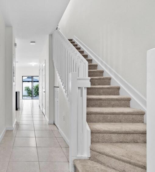 10606 W 33rd Ct, Hialeah, FL 33018 - stairway featuring tile patterned flooring and baseboards