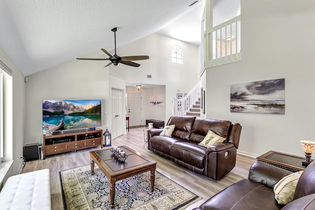 207 Jupiter Woods Dr, Jupiter, FL 33458 - living area featuring a ceiling fan, light wood-style floors, high vaulted ceiling, and stairway