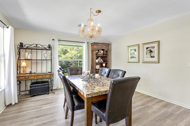 207 Jupiter Woods Dr, Jupiter, FL 33458 - dining area with a chandelier, light wood-type flooring, and a textured ceiling