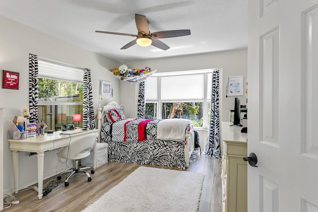 207 Jupiter Woods Dr, Jupiter, FL 33458 - bedroom featuring light wood finished floors, a ceiling fan, and a textured ceiling