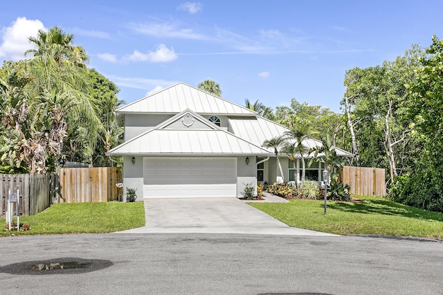 207 Jupiter Woods Dr, Jupiter, FL 33458 - view of front of property with a standing seam roof, stucco siding, concrete driveway, and an attached garage