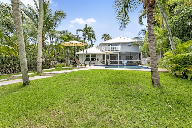 207 Jupiter Woods Dr, Jupiter, FL 33458 - rear view of house featuring a balcony, an outdoor pool, a yard, and a patio area