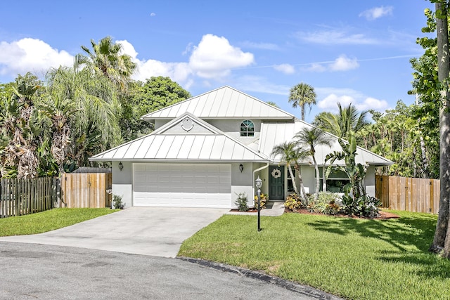 207 Jupiter Woods Dr, Jupiter, FL 33458 - view of front of house featuring a standing seam roof, stucco siding, driveway, and an attached garage