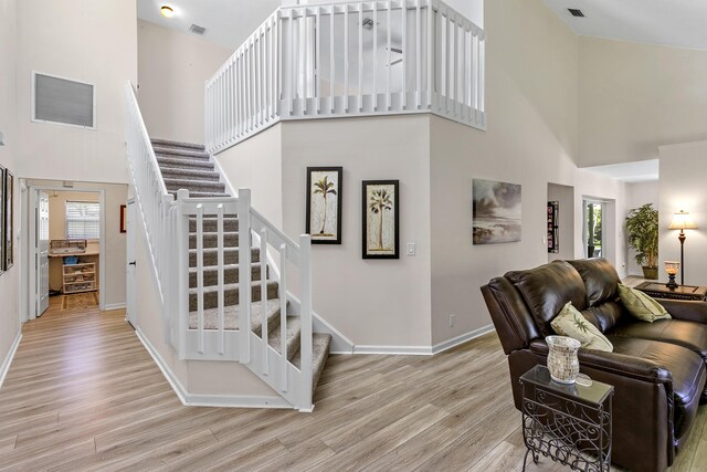 207 Jupiter Woods Dr, Jupiter, FL 33458 - staircase with a towering ceiling and wood finished floors