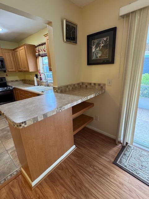 1023 Pheasant Run Dr Unit A, Fort Pierce, FL 34982 - kitchen featuring healthy amount of natural light, light countertops, a peninsula, and light wood-style flooring