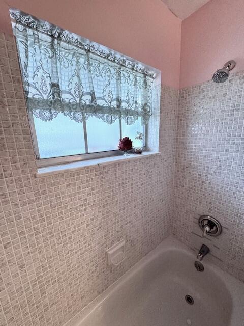 1023 Pheasant Run Dr Unit A, Fort Pierce, FL 34982 - bathroom with healthy amount of natural light and washtub / shower combination