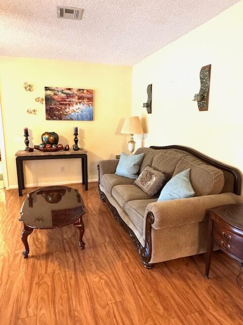 1023 Pheasant Run Dr Unit A, Fort Pierce, FL 34982 - living area featuring a textured ceiling and wood finished floors