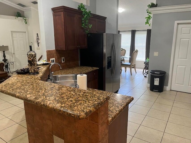 3718 SW Masilunas St, Port Saint Lucie, FL 34953 - kitchen with crown molding, light tile patterned floors, a peninsula, stainless steel fridge, and backsplash
