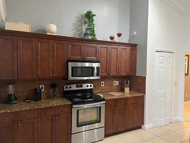 3718 SW Masilunas St, Port Saint Lucie, FL 34953 - kitchen with appliances with stainless steel finishes, tasteful backsplash, light tile patterned floors, dark stone countertops, and ornamental molding