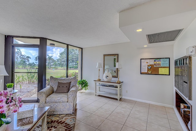 5390 Woodland Lakes Dr Unit 305, Palm Beach Gardens, FL 33418 - living room featuring light tile patterned floors, expansive windows, and a textured ceiling