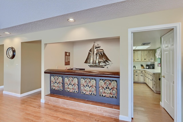 5390 Woodland Lakes Dr Unit 305, Palm Beach Gardens, FL 33418 - hall featuring light wood finished floors, a textured ceiling, and recessed lighting