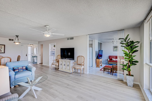 5390 Woodland Lakes Dr Unit 305, Palm Beach Gardens, FL 33418 - living area featuring a ceiling fan, light wood-style floors, and a textured ceiling