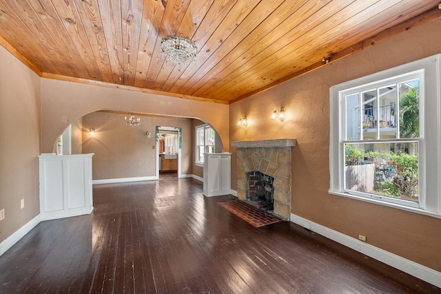 909 N L St, Lake Worth Beach, FL 33460 - unfurnished living room featuring a chandelier, arched walkways, hardwood / wood-style flooring, wood ceiling, and a fireplace