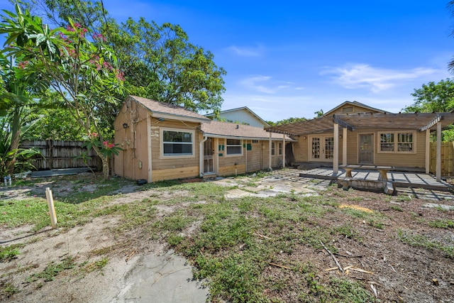 909 N L St, Lake Worth Beach, FL 33460 - rear view of property featuring a pergola, a fenced backyard, french doors, and a deck