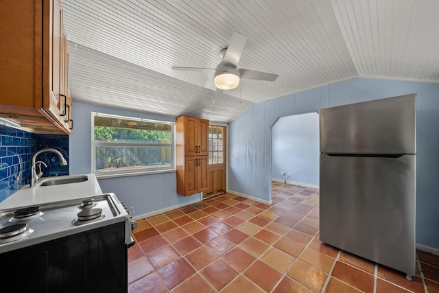 909 N L St, Lake Worth Beach, FL 33460 - kitchen with freestanding refrigerator, black electric range, brown cabinetry, lofted ceiling, and tile patterned floors