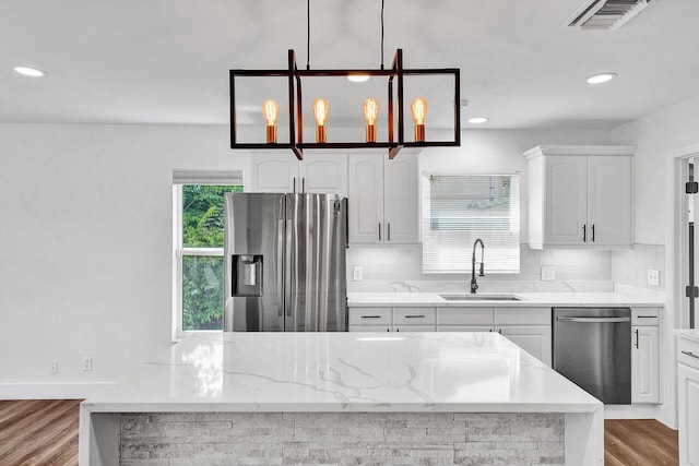 4110 NW 10th St, Delray Beach, FL 33445 - kitchen with appliances with stainless steel finishes, tasteful backsplash, wood finished floors, light stone counters, and recessed lighting