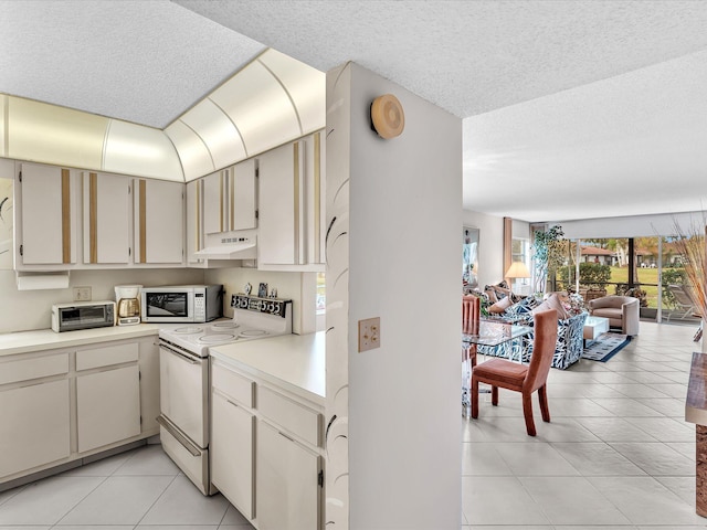 5869 Sugar Palm A Ct Unit A, Delray Beach, FL 33484 - kitchen featuring white appliances, under cabinet range hood, light countertops, light tile patterned floors, and a textured ceiling