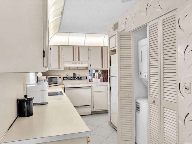 5869 Sugar Palm A Ct Unit A, Delray Beach, FL 33484 - kitchen featuring white appliances, stacked washing machine and dryer, light countertops, and under cabinet range hood
