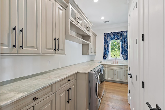 104 Hillcrest Dr, Sewalls Point, FL 34996 - laundry area with cabinet space, separate washer and dryer, light wood-type flooring, recessed lighting, and crown molding