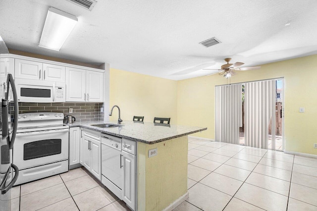 841 Summit Lake Dr, West Palm Beach, FL 33406 - kitchen featuring white appliances, a peninsula, ceiling fan, light tile patterned floors, and white cabinets