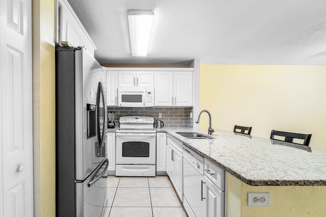 841 Summit Lake Dr, West Palm Beach, FL 33406 - kitchen featuring white appliances, a peninsula, light tile patterned flooring, white cabinets, and a textured ceiling