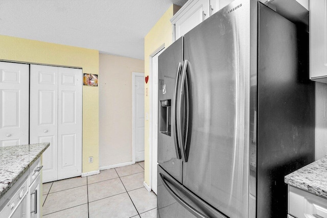 841 Summit Lake Dr, West Palm Beach, FL 33406 - kitchen featuring stainless steel fridge with ice dispenser, light tile patterned flooring, white cabinets, and light stone counters