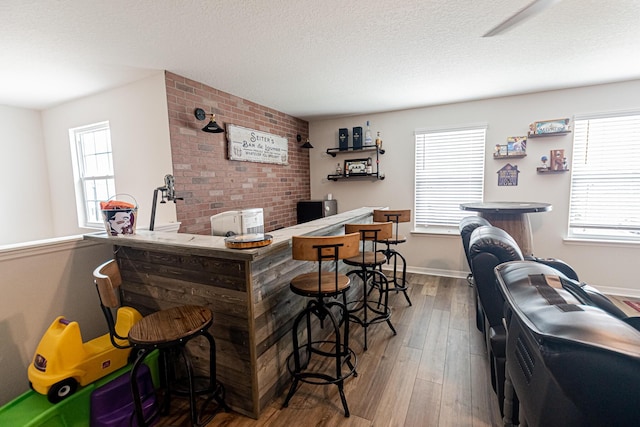 10782 SW Vasari Way, Port Saint Lucie, FL 34987 - bar area featuring hardwood / wood-style floors, plenty of natural light, and a textured ceiling