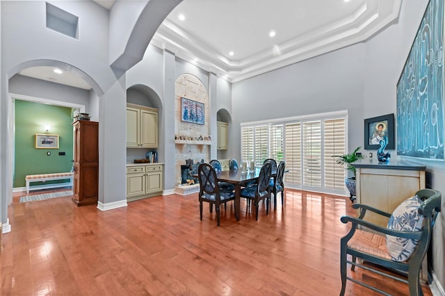 908 SW Squire Johns Ln, Palm City, FL 34990 - dining room with a towering ceiling, light wood finished floors, recessed lighting, a stone fireplace, and arched walkways