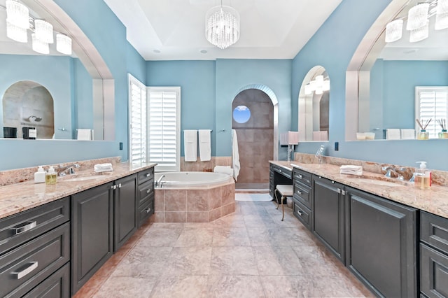 908 SW Squire Johns Ln, Palm City, FL 34990 - bathroom with two vanities, a garden tub, a chandelier, and a tile shower