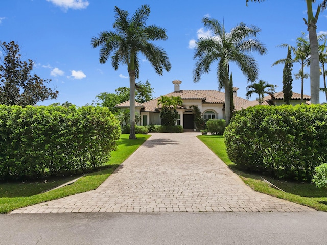 908 SW Squire Johns Ln, Palm City, FL 34990 - mediterranean / spanish house with a tile roof, decorative driveway, stucco siding, and a front yard