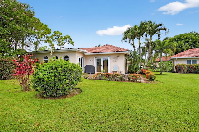 2 Fairway Dr, Boynton Beach, FL 33436 - back of property featuring stucco siding, french doors, a lawn, a tiled roof, and a patio