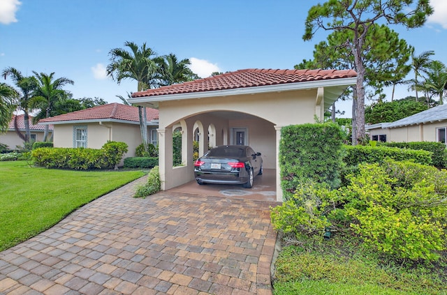 2 Fairway Dr, Boynton Beach, FL 33436 - mediterranean / spanish-style home with a tile roof, a front lawn, decorative driveway, an attached carport, and stucco siding