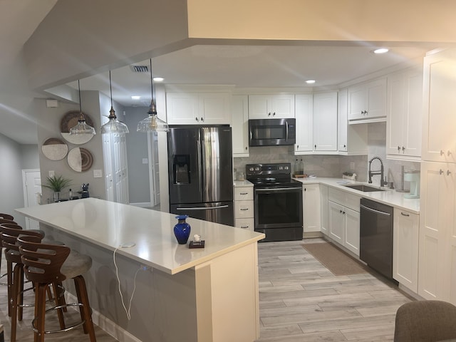 5710 Coach House F Cir Unit F, Boca Raton, FL 33486 - kitchen with stainless steel appliances, light wood-style floors, white cabinetry, backsplash, and recessed lighting