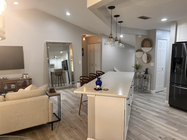 5710 Coach House F Cir Unit F, Boca Raton, FL 33486 - kitchen featuring stainless steel refrigerator with ice dispenser, light wood finished floors, white cabinets, a breakfast bar area, and light countertops