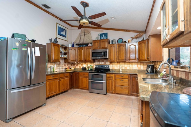 2573 SW Savona Blvd, Port Saint Lucie, FL 34953 - kitchen featuring stainless steel appliances, brown cabinetry, lofted ceiling, tasteful backsplash, and dark stone countertops