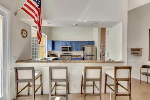 5129 Elpine Way, Riviera Beach, FL 33418 - kitchen with appliances with stainless steel finishes, blue cabinets, a kitchen breakfast bar, and a peninsula