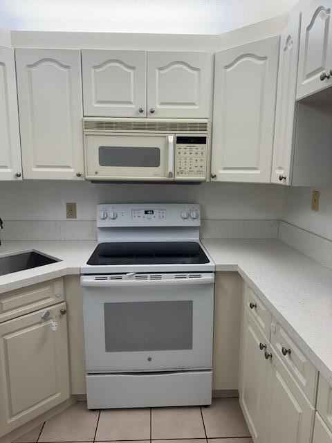717 Sunny Pine Way Unit A2, Greenacres, FL 33415 - kitchen featuring white appliances, light tile patterned floors, white cabinets, and light countertops