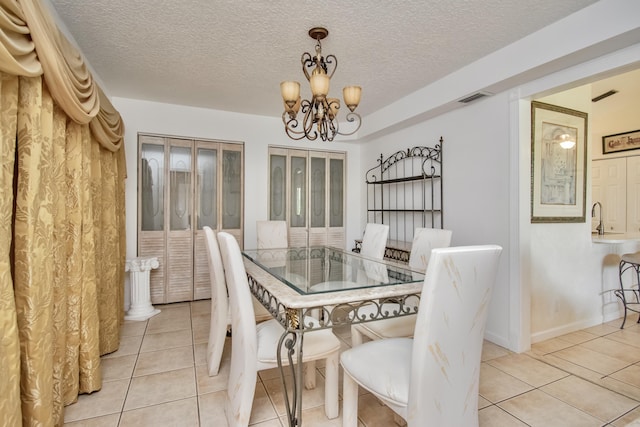 5064 El Claro Cir, West Palm Beach, FL 33415 - dining room featuring a chandelier, light tile patterned floors, and a textured ceiling